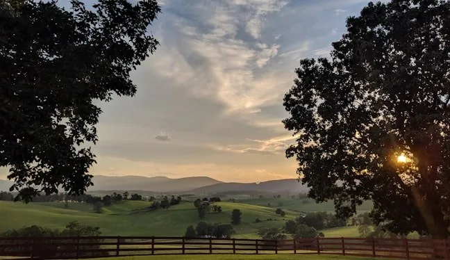 Farm fields in a broad green mountain valley